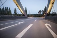 a long bridge that has lights on and pointing up at the right direction during sunset