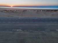 an aerial view of the sunset over a road on the beach and a beach line