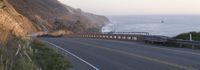 a curved highway on the pacific coast at sunset near a clifftop in california state