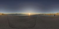 a panorama photo taken on the beach at sunset shows a beautiful body of water and buildings