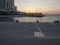 a parking lot in front of a body of water at sunset with boats on it