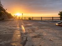 an empty parking lot is in front of the sun during sunset in a scenic spot