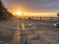 an empty parking lot is in front of the sun during sunset in a scenic spot