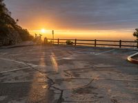 an empty parking lot is in front of the sun during sunset in a scenic spot