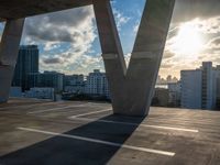 the sun is setting over a parking lot with modern buildings in the background, with low shadows