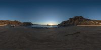 an 360 - pan picture taken at sunset on the beach with rocky formations in front