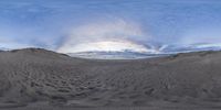 the view looking towards the clouds from the sand dunes at sunset, taken with a fisheye lens