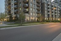 a person riding on a skate board at sunset in an urban street area by some tall buildings