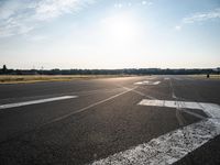 an airplane taking off from a small airport runway at sunset and sun shining down on it