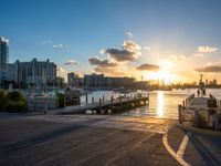 a pier with boats on water during sunset time in the cityscape area of florida