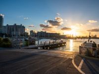 a pier with boats on water during sunset time in the cityscape area of florida