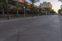 the sun sets over the parking lot at the university of san diego at dusk, overlooking the building's roof and sidewalk