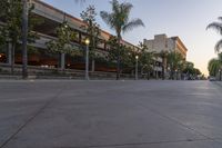 the sun sets over the parking lot at the university of san diego at dusk, overlooking the building's roof and sidewalk