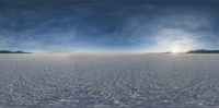 the sun is shining behind the mountains on an ice sheeted field at sunset time