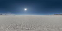 an image of the sun setting over a vast plain with some snow covered ground,