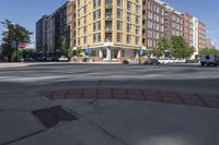 this is an outside view of a city intersection at sunset time with buildings and other cars