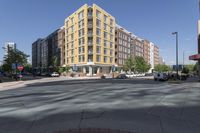 this is an outside view of a city intersection at sunset time with buildings and other cars