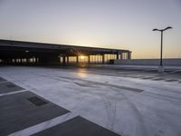 a parking lot that has a sky view at sunset behind it with parking spots near the side