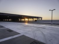 a parking lot that has a sky view at sunset behind it with parking spots near the side