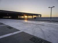 a parking lot that has a sky view at sunset behind it with parking spots near the side