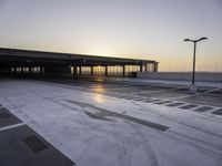 a parking lot that has a sky view at sunset behind it with parking spots near the side