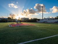 a view of the football field at sunset as the sun shines behind the field