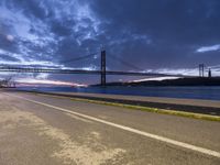 view across the highway of large bridge, a large body of water and a long bridge at sunset