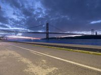 view across the highway of large bridge, a large body of water and a long bridge at sunset