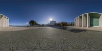 a 360 - view of the sun setting on a building next to a stone path