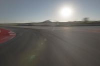 a blurry image shows a sun shining brightly over an empty track on a clear day