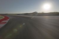 a blurry image shows a sun shining brightly over an empty track on a clear day