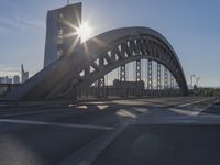 the sun shines over a city street bridge with a curved walkway that runs across