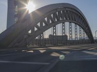 the sun shines over a city street bridge with a curved walkway that runs across