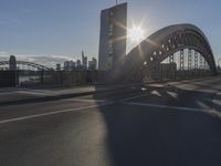 the sun shines over a city street bridge with a curved walkway that runs across