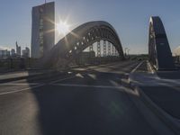 the sun shines over a city street bridge with a curved walkway that runs across