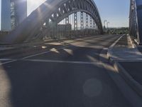 the sun shines over a city street bridge with a curved walkway that runs across