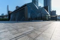 this is an image of modern buildings and a public square with some plants on the ground