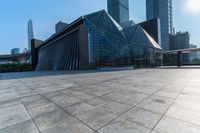 this is an image of modern buildings and a public square with some plants on the ground