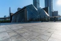 this is an image of modern buildings and a public square with some plants on the ground