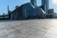 this is an image of modern buildings and a public square with some plants on the ground