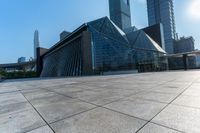 this is an image of modern buildings and a public square with some plants on the ground