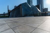 this is an image of modern buildings and a public square with some plants on the ground