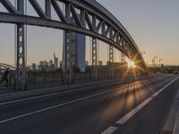 the sun shines over a long bridge in a city area with high rises buildings in the background