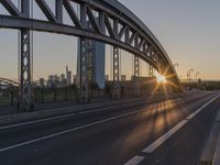 the sun shines over a long bridge in a city area with high rises buildings in the background