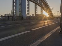 the sun shines over a long bridge in a city area with high rises buildings in the background