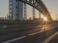 the sun shines over a long bridge in a city area with high rises buildings in the background