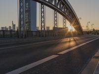 the sun shines over a long bridge in a city area with high rises buildings in the background