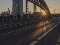 the sun shines over a long bridge in a city area with high rises buildings in the background