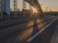 the sun shines over a long bridge in a city area with high rises buildings in the background