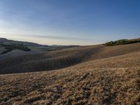 an image of a beautiful day in the hills with no clouds in the sky while someone has fallen grass and walks